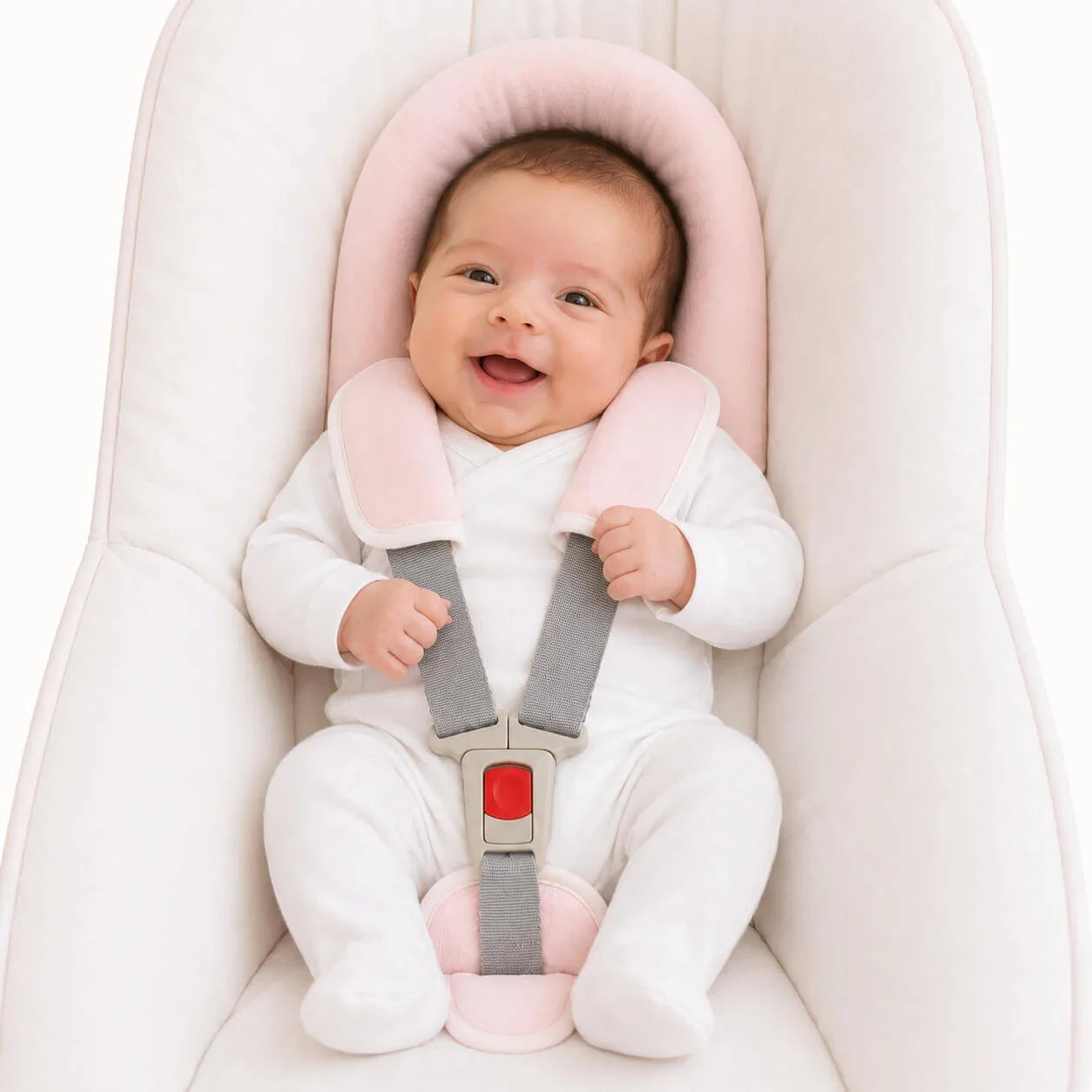 Bebé sorridente em cadeirinha com roupa branca e acessórios rosa para conforto e segurança