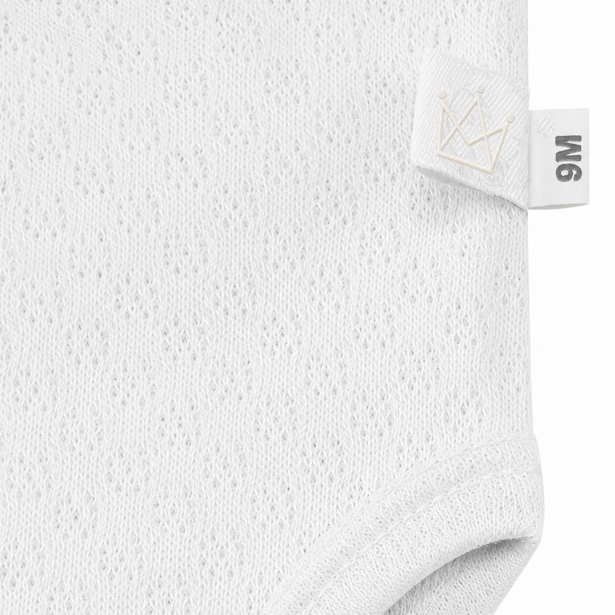 Roupa de bebé branca com etiqueta 9M e coroa bordada, tecido respirável e confortável