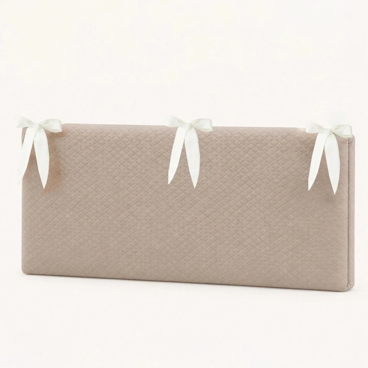 Almofada de bebê com laços brancos e textura acolchoada para conforto e delicadeza