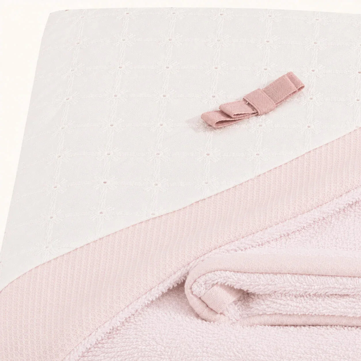 Manta de bebê rosa com detalhe em laço e textura delicada, ideal para recém-nascidos