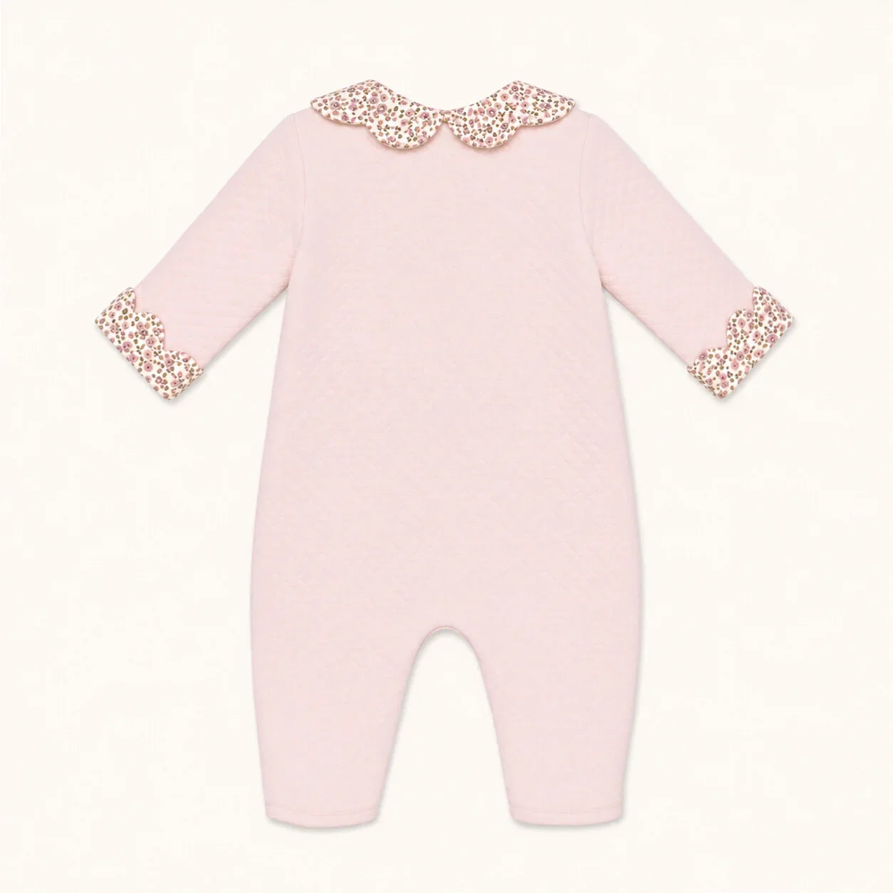 Macacão rosa bebê com gola e punhos florais, ideal para recém-nascidos, confortável e delicado.
