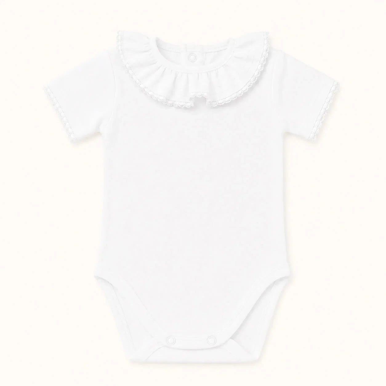 Body branco para bebê com gola franzida e detalhes em renda, ideal para recém-nascidos