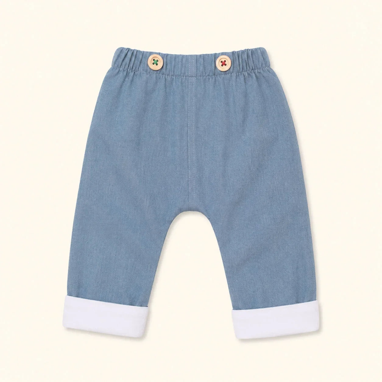 Calças de bebé em denim azul com botões e punhos brancos, confortáveis e macios