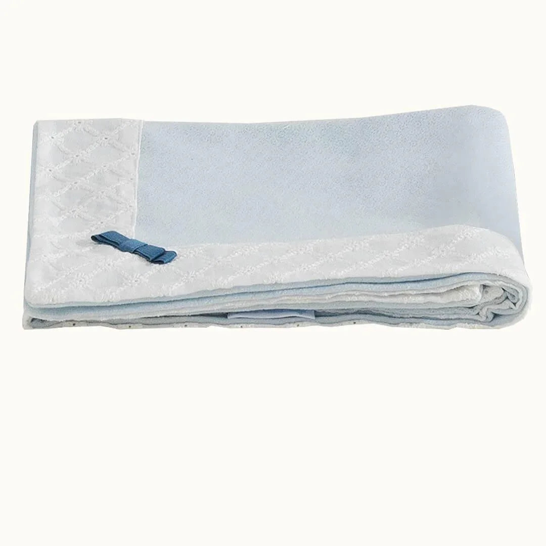 Manta de bebê azul com borda branca e laço decorativo, enxoval para recém-nascido.