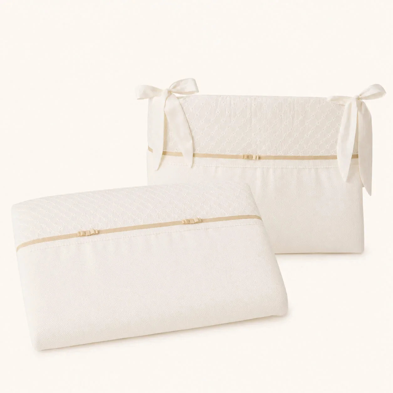 Conjunto de enxoval bebê em tecido macio com laços delicados e acabamento em dourado