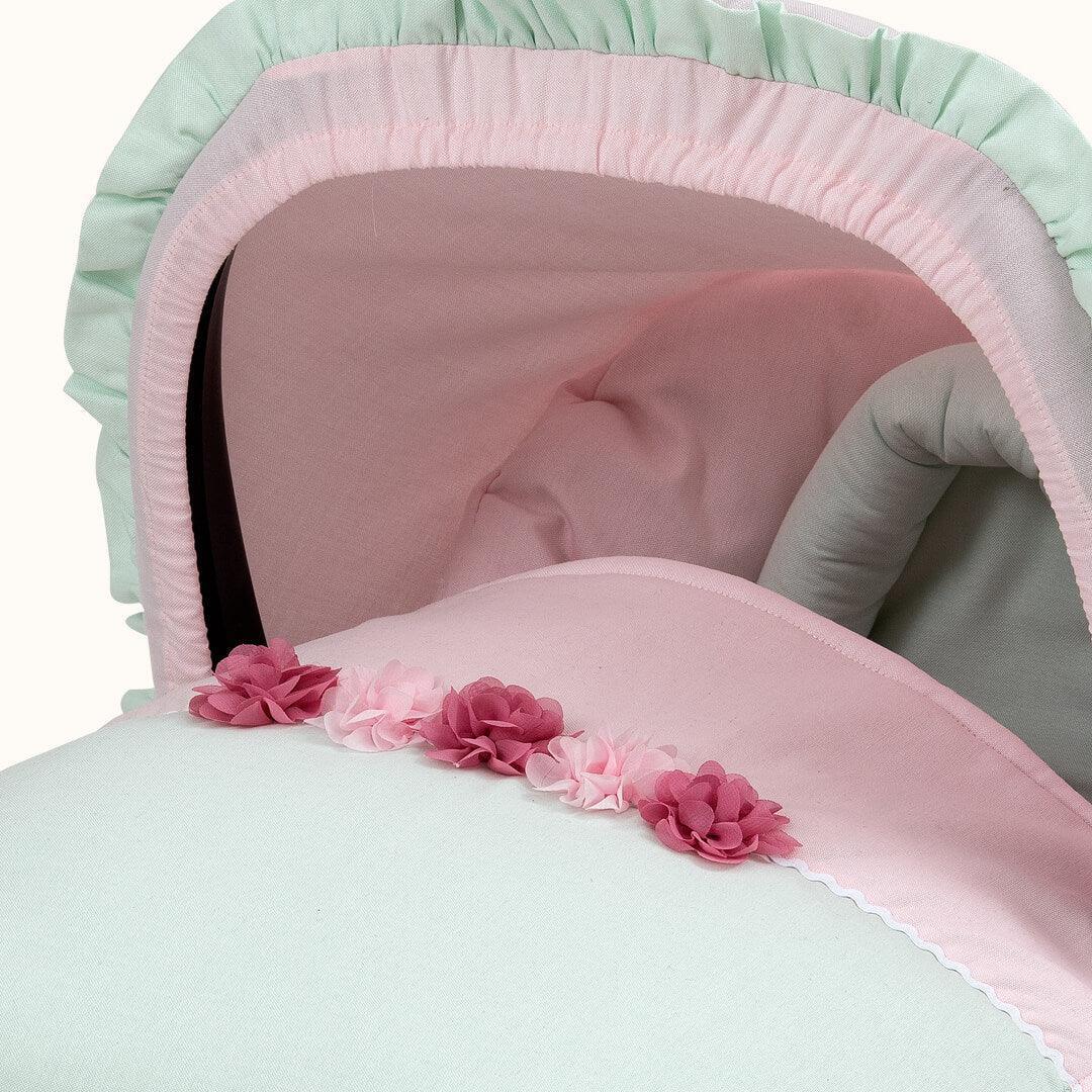 Forra de carrinho de bebé rosa e verde com flores delicadas, tecido macio e confortável.