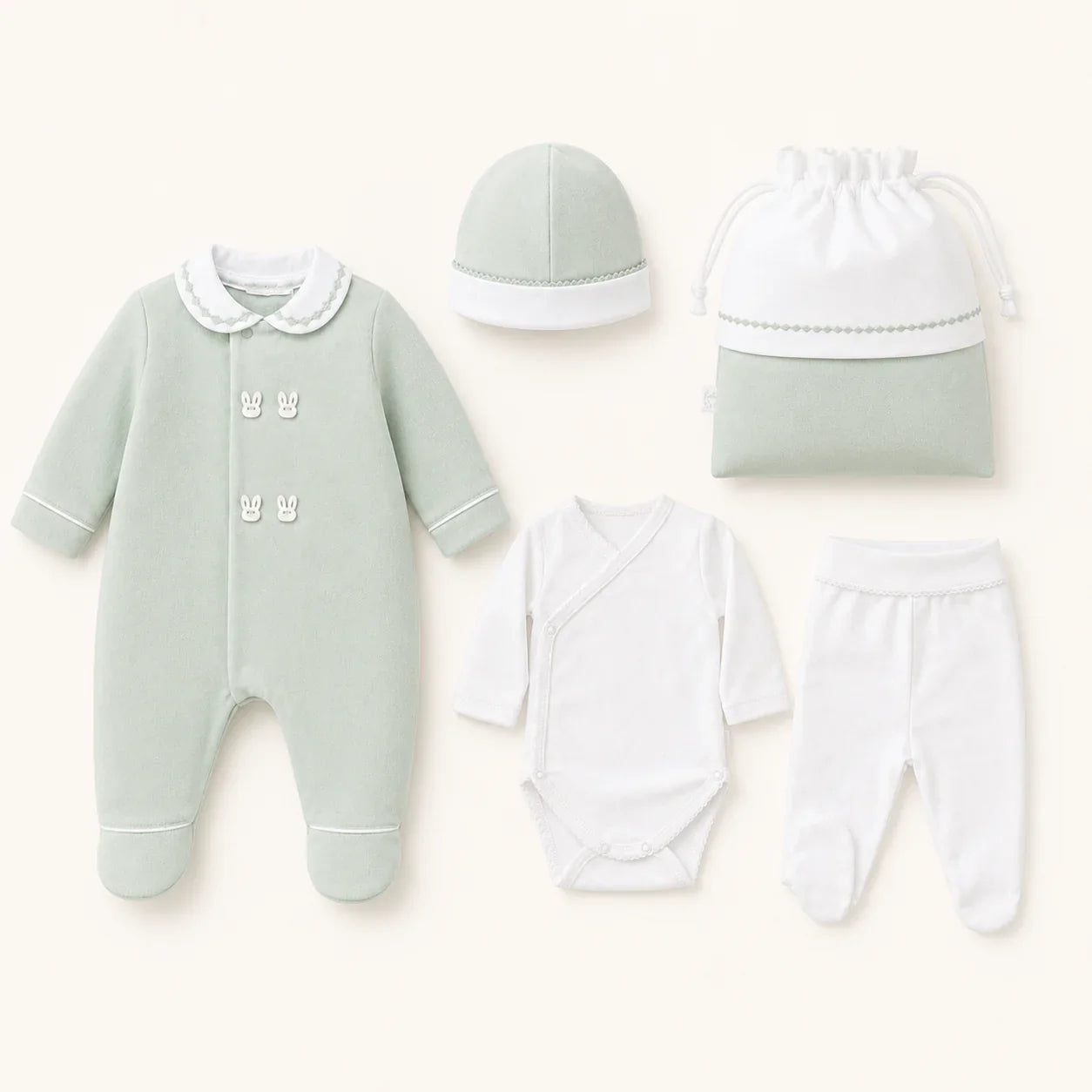 Conjunto enxoval de bebé com macacão verde, body, calça, touca e saco de algodão.