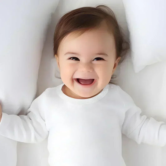 bebê sorrindo deitado, vestindo camisola branca de algodão com mola, roupa confortável para recém-nascido