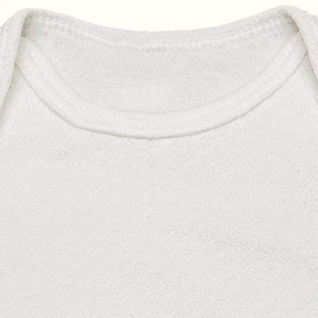 Detalhe de body de bebê branco em algodão, gola americana, manga curta, tecido suave.
