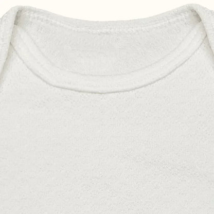 Detalhe de body de bebê branco em algodão, gola americana, manga curta, tecido suave.