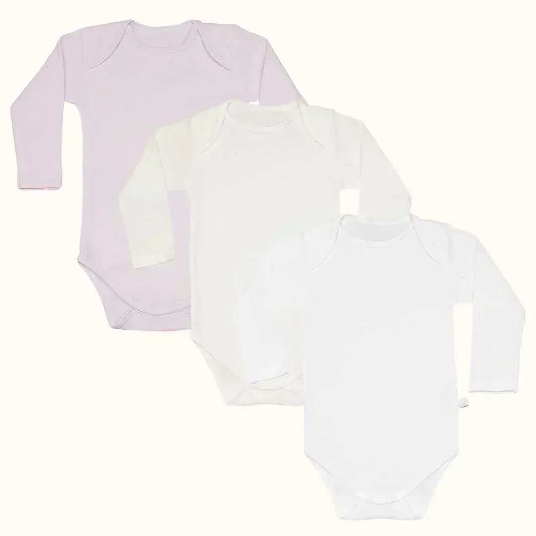 Três bodies de manga comprida para bebé em tons pastel e branco, algodão, confortáveis.