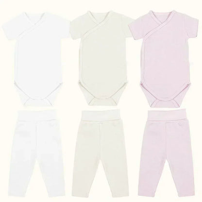 Kit com 3 bodies de manga curta e 3 calças sem pé para bebê, em tons branco, bege e rosa.