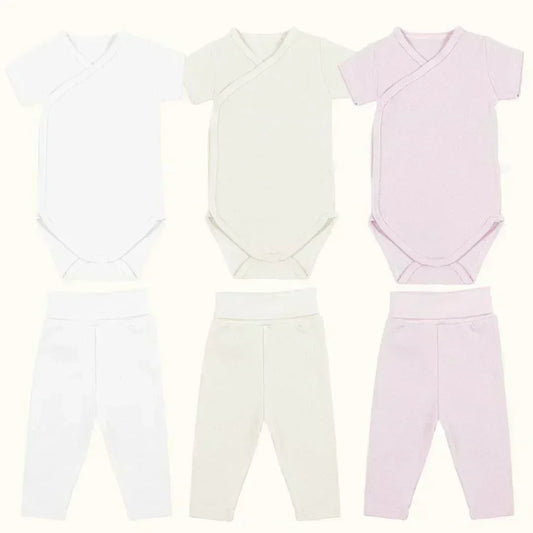 Kit com 3 bodies de manga curta e 3 calças sem pé para bebê, em tons branco, bege e rosa.