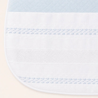 Babete de bebé branco com detalhes azul claro e bordado delicado, tecido suave.
