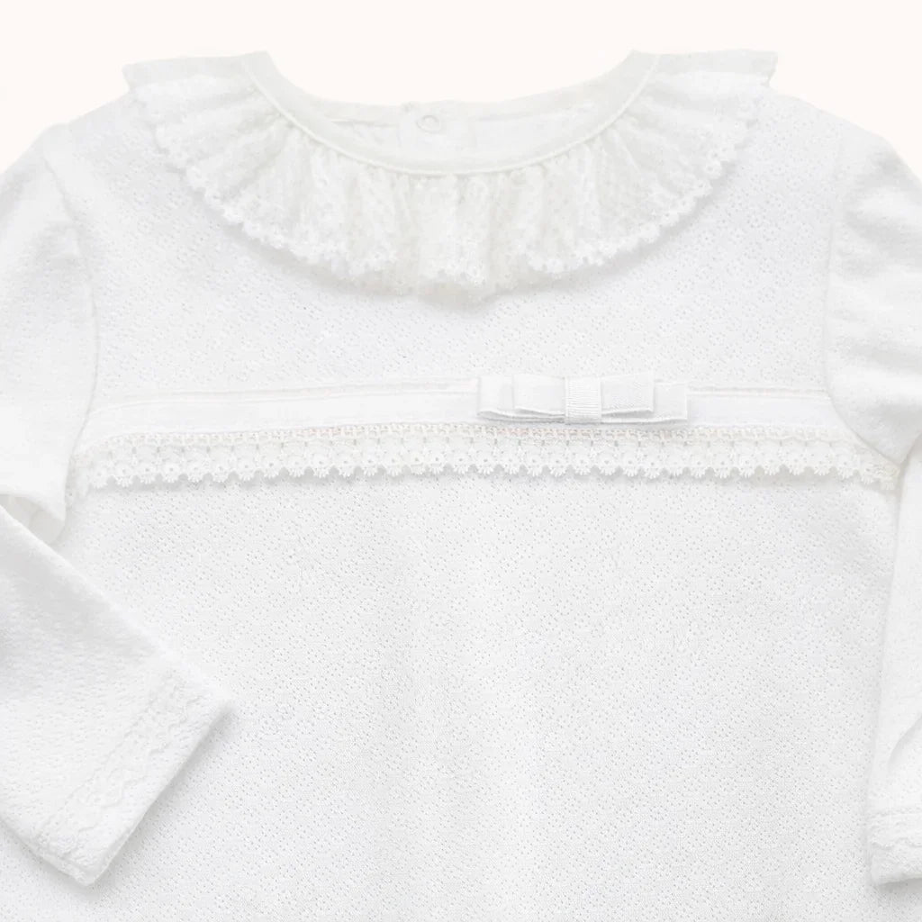 Babygrow branco de algodão para recém-nascido com gola rendada, laço e detalhe em renda.