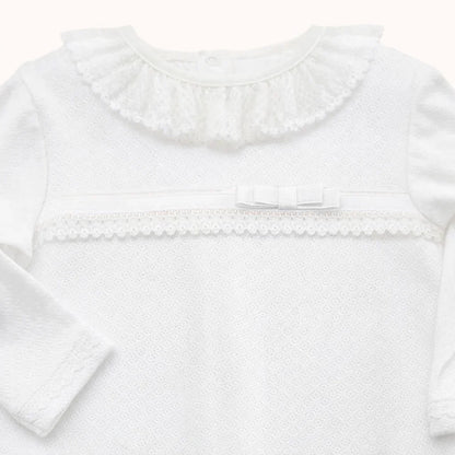 Babygrow branco de algodão para recém-nascido com gola rendada, laço e detalhe em renda.