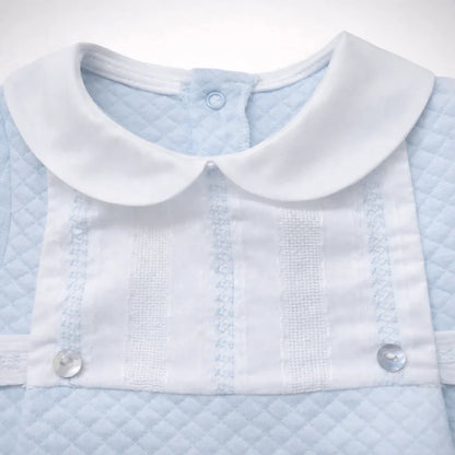 Babygrow azul claro de algodão para bebê, com gola branca e detalhes em renda e botões.