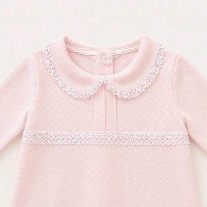 Babygrow rosa para bebé em algodão suave, gola peter pan e detalhe de renda branca.