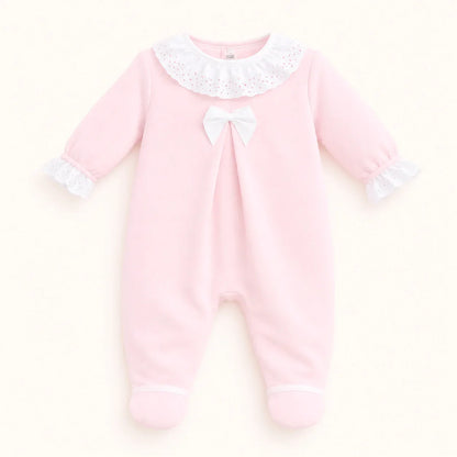 Babygrow rosa de malha para bebê com gola e punhos de renda branca, laço no peito.