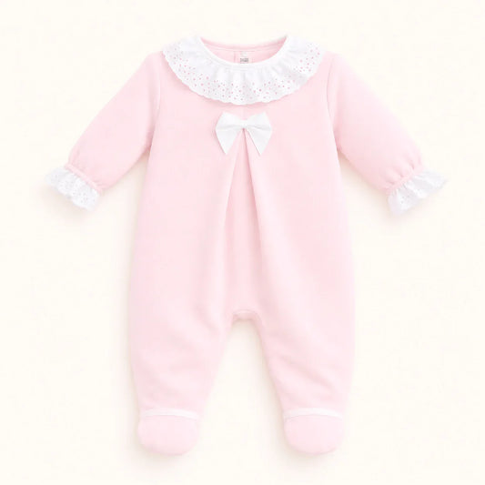 Babygrow rosa de malha para bebê com gola e punhos de renda branca, laço no peito.