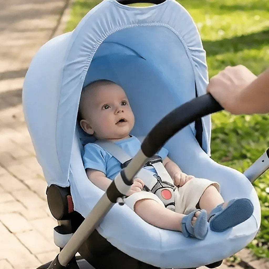 Bebê confortável em carrinho azul, ao ar livre, roupa macia para pele delicada
