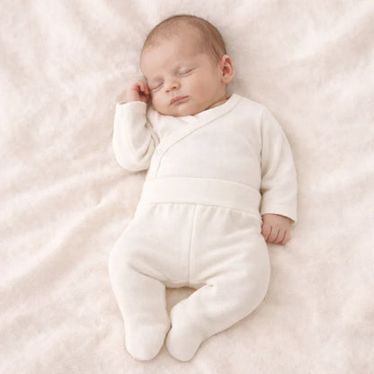 Bebê dormindo com body cruzado e calça beige, roupa confortável para recém-nascido