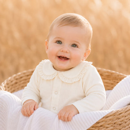 bebé sorridente vestido com body de gola em folho em malha algodão macio bege, ideal para colocar por baixo dos conjuntos de malha.