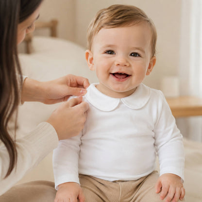 Bebé feliz vestido com camisola para bebé com gola Peter Pan branco com abertura até abaixo para facilitar a troca de roupa