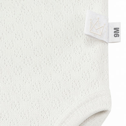 Roupa de bebé em tecido leve com etiqueta 9M e coroa bordada, ideal para recém-nascidos