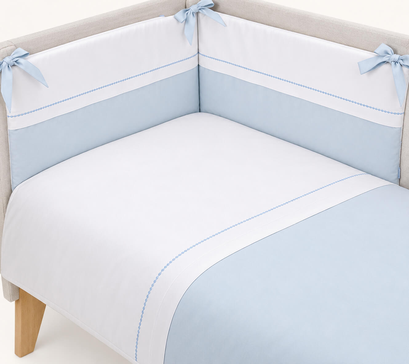 Cama de grades para bebé composto por um edredão e resguardo em tecido piquet algodão branco e azul