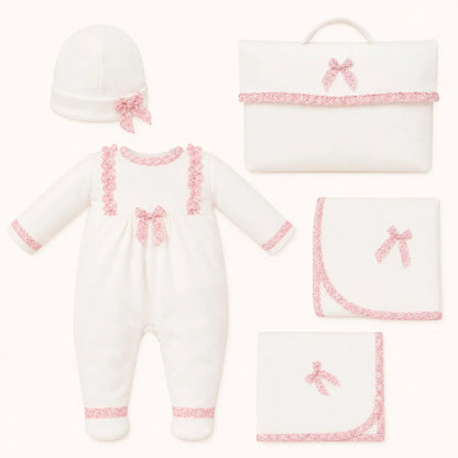 Conjunto primeira roupa de bebé branco com detalhes rosa, inclui macacão, touca, manta e mala.