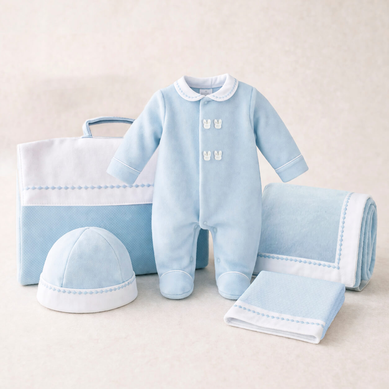 Conjunto para primeira roupa de bebé composto por babygrow, gorro, manta, fralda e saco para guardar a roupa