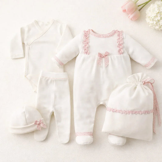 Conjunto de roupa de bebé recém-nascido branco com detalhes rosa, inclui body, calça, gorro, saco e macacão.