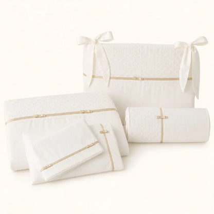 Roupa de Berço de bebé bege com detalhes dourados e laços composto por edredão,  resguardo para as grades, lençóis e travesseiro decorativo