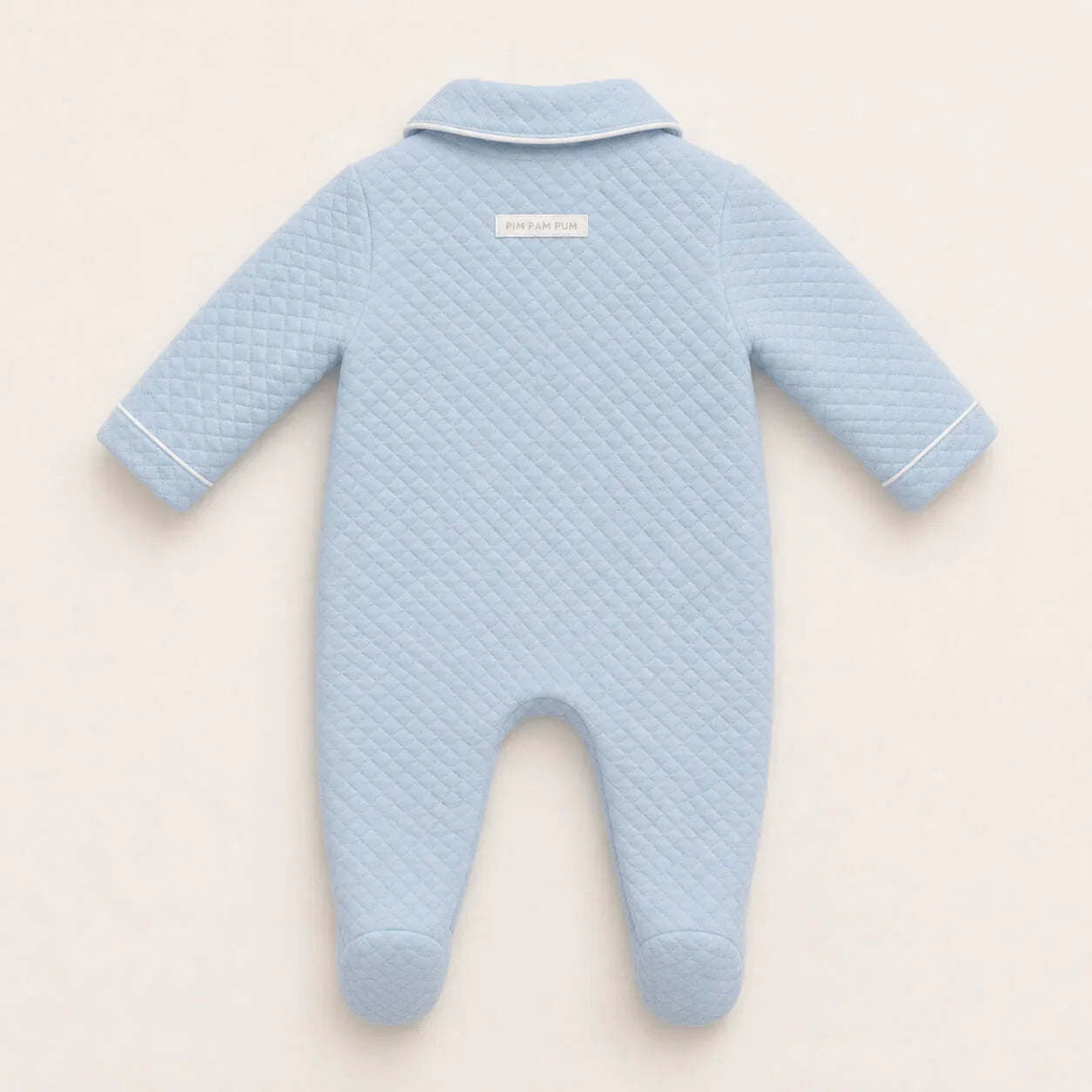 Costas do babygrow em malha azul com pormenor da etiqueta de marca no exterior na peça 