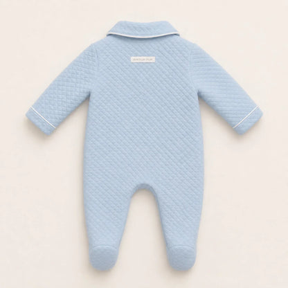 Costas do babygrow em malha azul com pormenor da etiqueta de marca no exterior na peça 