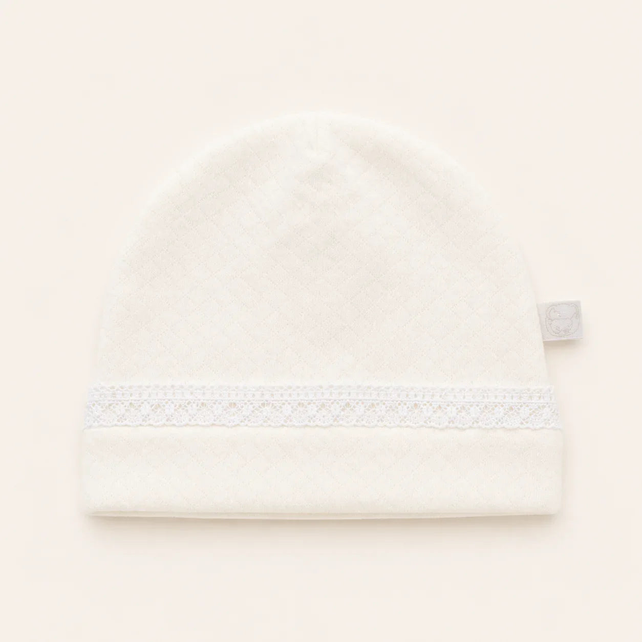 Gorro de malha bege para bebê, com faixa de renda delicada, ideal para recém-nascido.