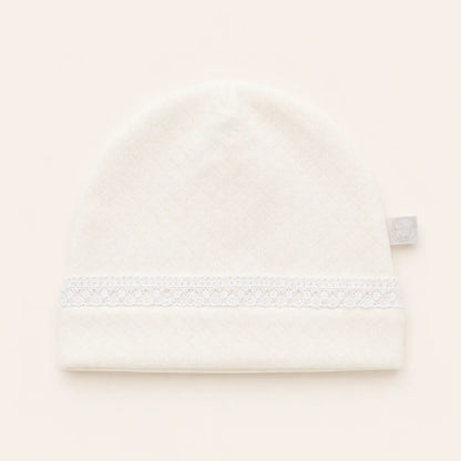 Gorro de malha bege para bebê, com faixa de renda delicada, ideal para recém-nascido.