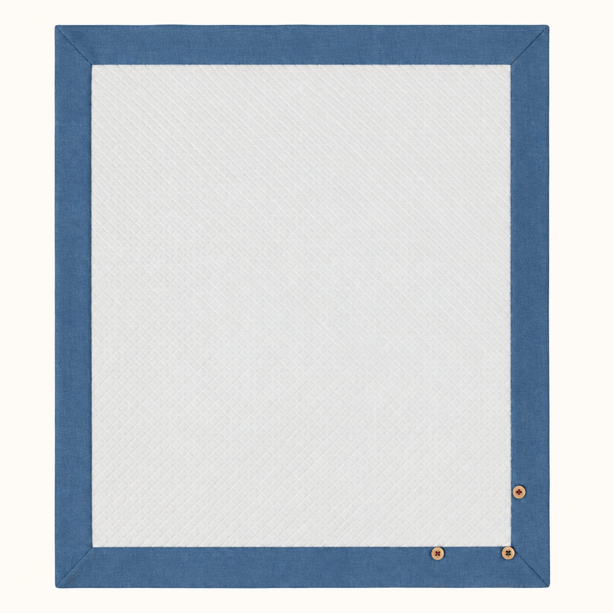 Manta rectangular para bebé em malha branca losango de algodão. Barras em denim azul à volta e 3 botões de madeira decorativos. Essencial para o berço