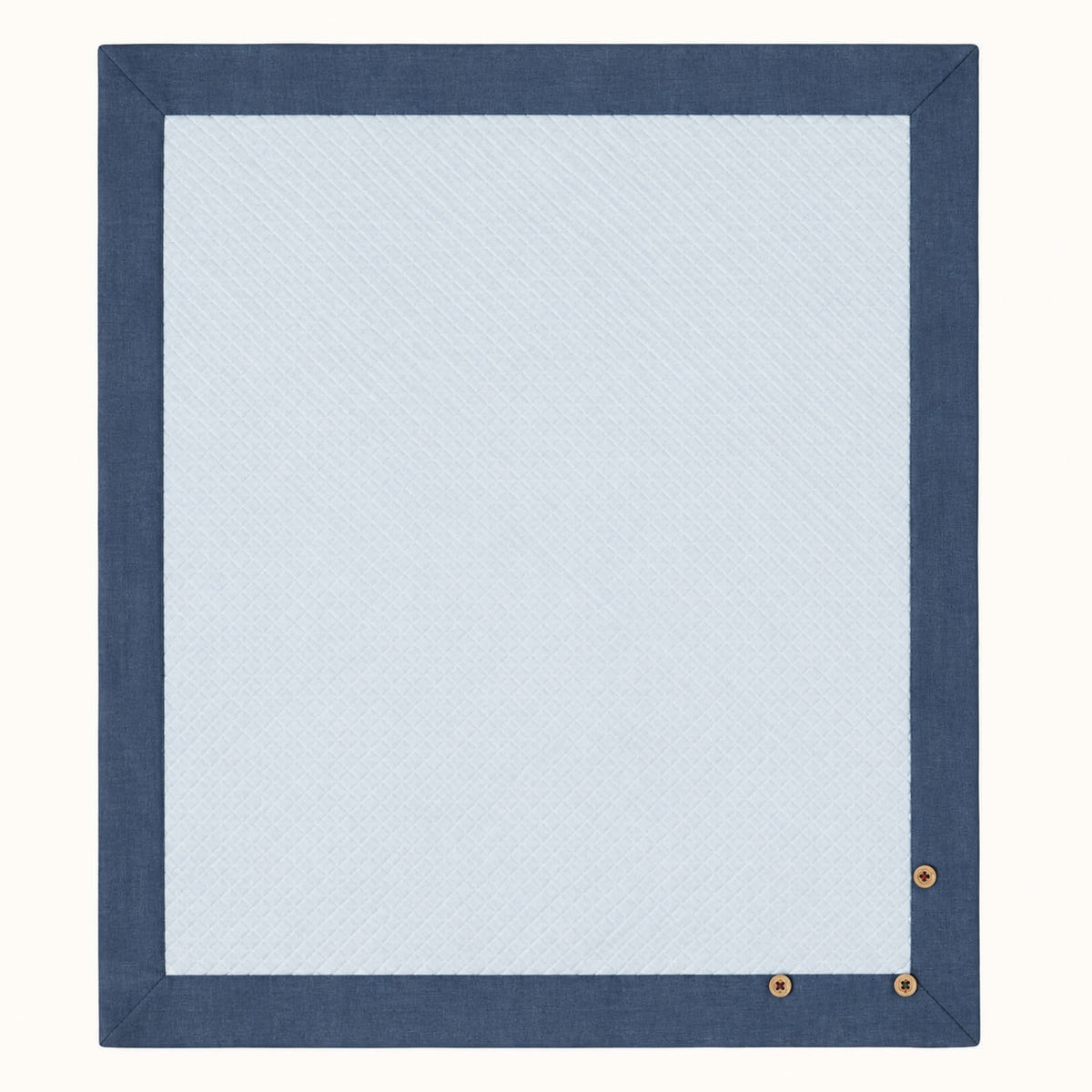 Manta rectangular essencial para bebé em malha losango de algodão azul claro e com barras azuis denim à volta.