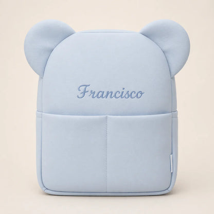 Mochila infantil azul clara com orelhas e nome Francisco bordado na frente.