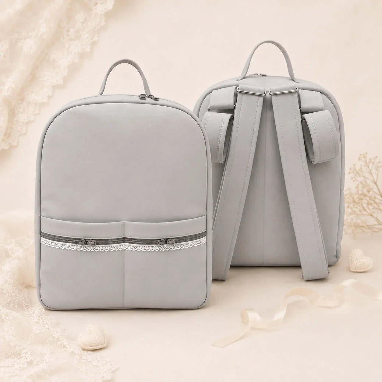 Mochila cinza para bebê com detalhes em renda, ideal para enxoval e conforto
