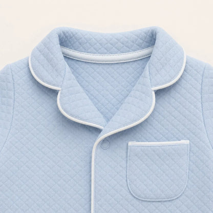 Pormenor do babygrow em malha azul com pormenor branco inspirado nas camisas de homem 