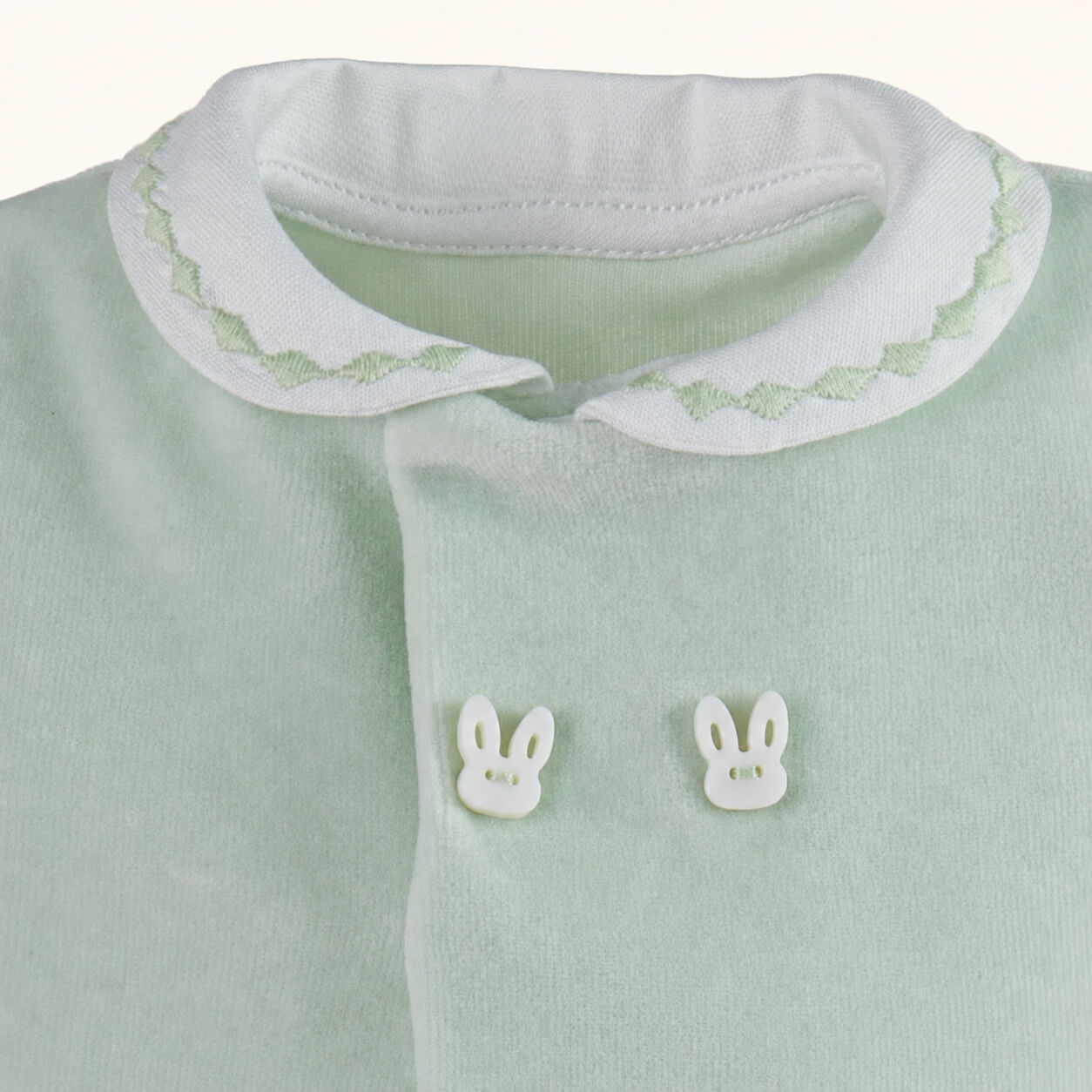 Pormenor do babygrow sem etiquetas irritantes. Gola branca com bordado verde