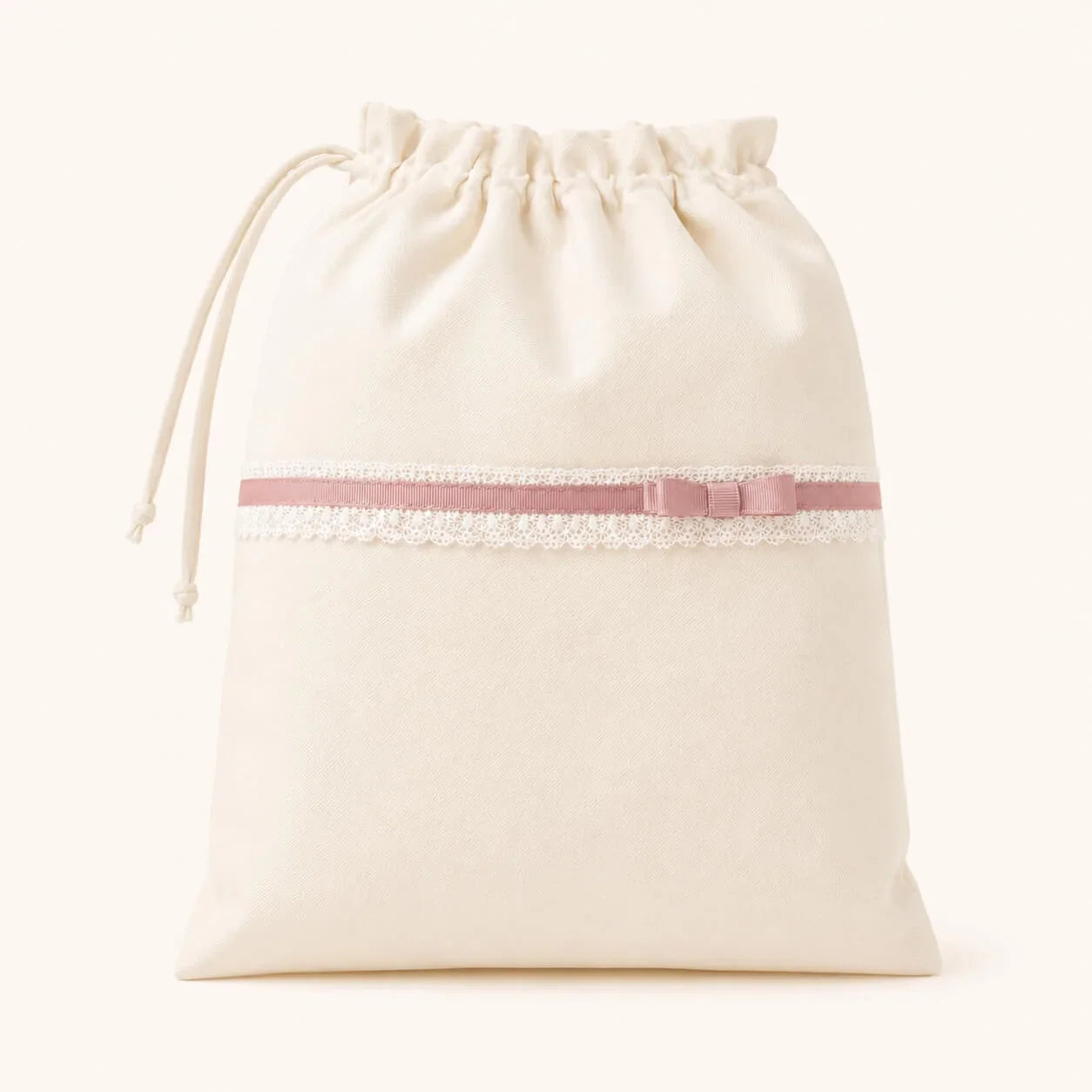Saco de malha bege com laço rosa e renda, ideal para enxoval de bebé 