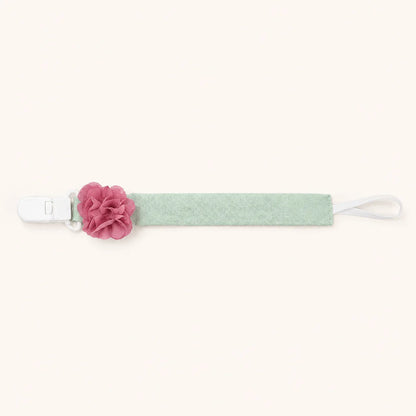 Suporte de chupeta verde com detalhe de flor rosa, acessório para bebé.