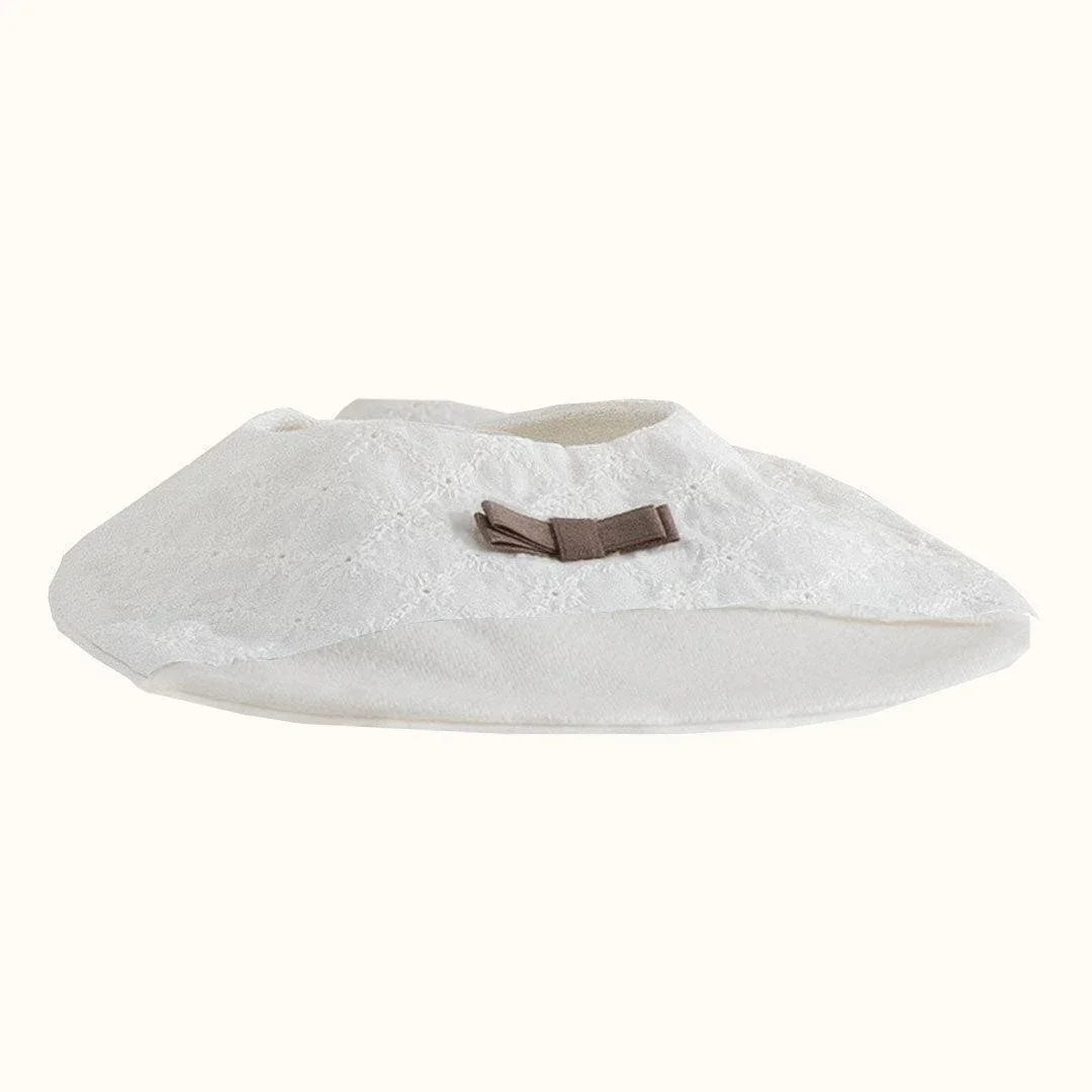 babete de bebé em malha bege com laço decorativo, ideal para enxoval de recém-nascido