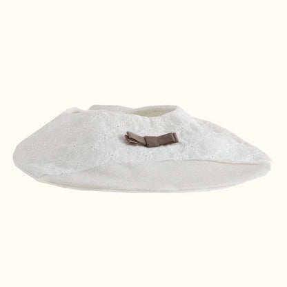 babete de bebé em malha bege com laço decorativo, ideal para enxoval de recém-nascido