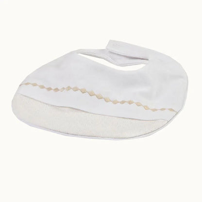 Babete de algodão bege para bebé com detalhe em zig zag, ideal para enxoval de recém-nascido.
