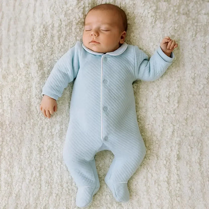 Bebê dormindo com babygrow azul claro de algodão, roupa confortável para recém-nascido